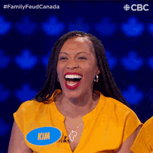 a woman in a yellow shirt with a blue name tag that says kim
