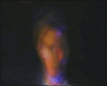 a blurry picture of a person in a dark room with a rainbow of colors