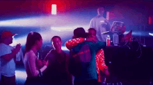a group of people are dancing at a party in a dark room .
