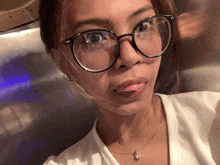 a close up of a woman wearing glasses and a white shirt