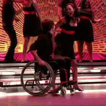 a man in a wheelchair is dancing with a woman