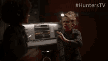 a woman sits at a desk in front of a machine with the hashtag #hunterstv on the bottom