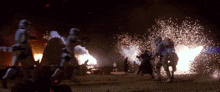 a group of storm trooper soldiers are standing in front of a fire .