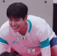 a young man in a white shirt is smiling while doing push ups in a gym .