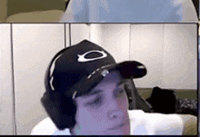 a man wearing a hat and headphones is looking at the camera .