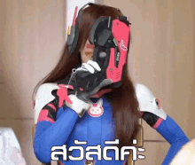a woman in a bunny costume is holding a gun in front of her face and the words " สวัสดี คะ " are below her