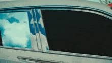 a close up of a car window with a reflection of clouds