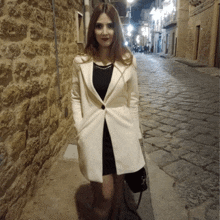 a woman wearing a white coat and a black dress