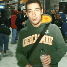 a man wearing a green hoodie that says abercrombie