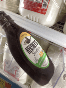 a bottle of hershey 's chocolate syrup sits on a shelf