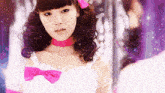 a girl with a pink bow in her hair looks at her reflection in a mirror