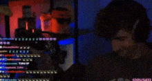 a blurry picture of a man sitting in front of a computer screen