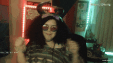 a woman wearing sunglasses and bunny ears is smiling in front of a screen that says gang 16/30