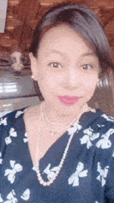 a woman is wearing a pearl necklace and earrings
