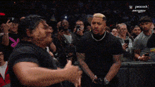 a wrestling match is being shown on peacock and a crowd is watching