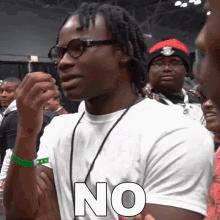a man wearing glasses and a white shirt with the word no on it