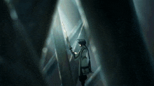 a person standing in a dark room with a sword in their hand