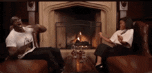 a man and woman are sitting in front of a fireplace
