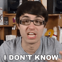 a man wearing glasses is making a funny face and says i don 't know