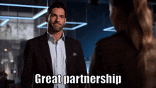 a man in a suit is talking to a woman and the words great partnership are on the screen