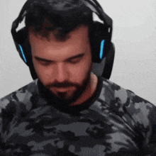 a man wearing headphones and a camo shirt looks down