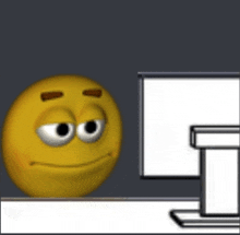 a yellow smiley face is sitting in front of a computer screen .