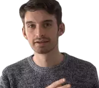a man with a beard is wearing a grey sweater and looking at the camera .