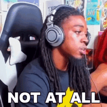 a man wearing headphones is sitting in a chair and says not at all
