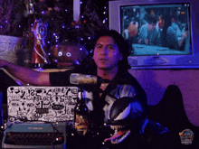 a man sitting in front of a computer with a sticker on his laptop that says no