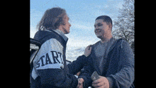 a man and a woman are shaking hands while a man holds a piece of money .