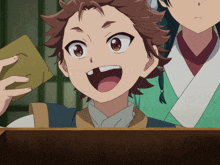a boy in a green kimono is smiling with his mouth wide open