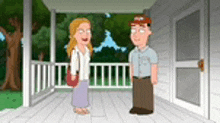 a man and a woman are standing on a porch of a house .