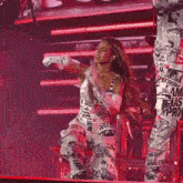 a woman in a newspaper print jumpsuit is dancing on stage