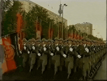 a row of soldiers marching down a street in front of a building