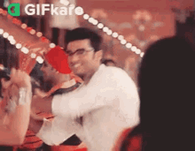 a man in glasses is dancing in a crowd of people .