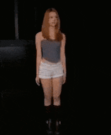a woman in shorts is dancing in the dark