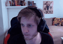 a man wearing headphones is sitting in front of a poster that says you
