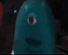 a close up of a blue object with one eye