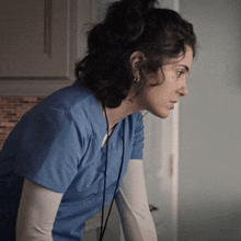 a woman in a blue scrub top with a cord around her neck