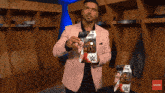 a man in a pink suit is holding a wwe action figure