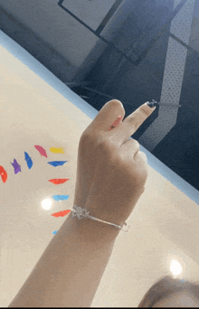 a woman wearing a bracelet with a heart on it