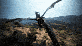 a dragon is flying over a rocky area with mountains in the background