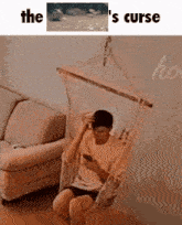 a man is sitting in a hammock and looking at his phone .