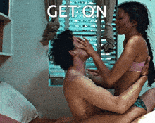 a man and a woman are kissing in front of a window with the word geton written on the bottom
