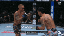 two men are fighting in a boxing ring and one of them is wearing a venum shorts
