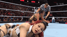 two women in a wrestling ring with a bottle of prime water