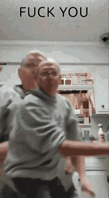 a man is dancing in a kitchen with the words fuck you written above him