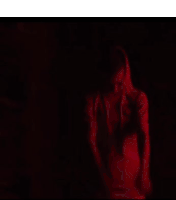 a woman in a red shirt is surrounded by red lights and letters .