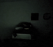 a blurry picture of a person standing in a dark room with a laptop .