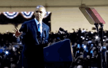 barack obama stands at a podium giving a speech